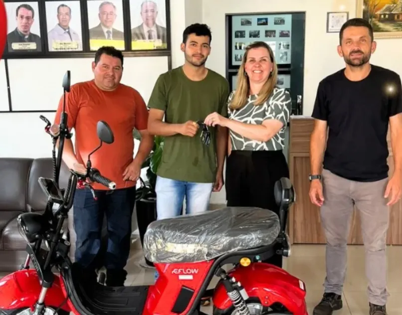 Ganhador recebendo a scooter elétrica